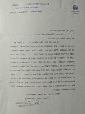 Color photograph of a black ink typed letter with a black ink handwritten signature towards the bottom. 